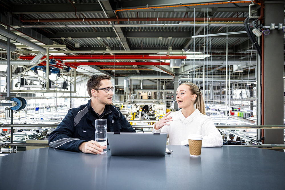 Employees discussing workplace topics in a production environment.