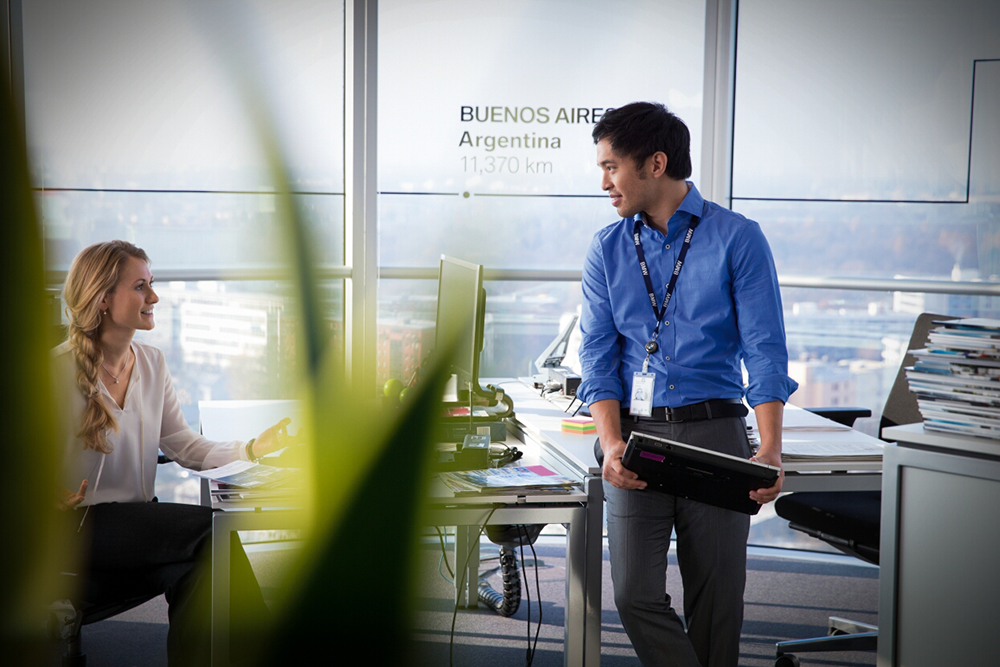 Employee presenting information to colleagues during a facilities management meeting.