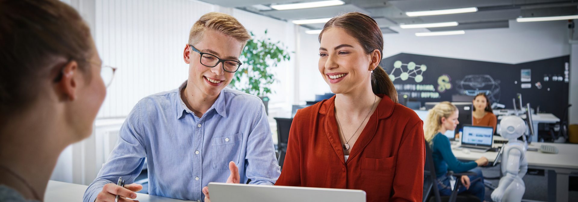 Three apprentices having a conversation in the office