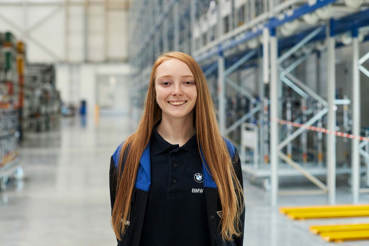 Alice, a technical apprentice in a hallway