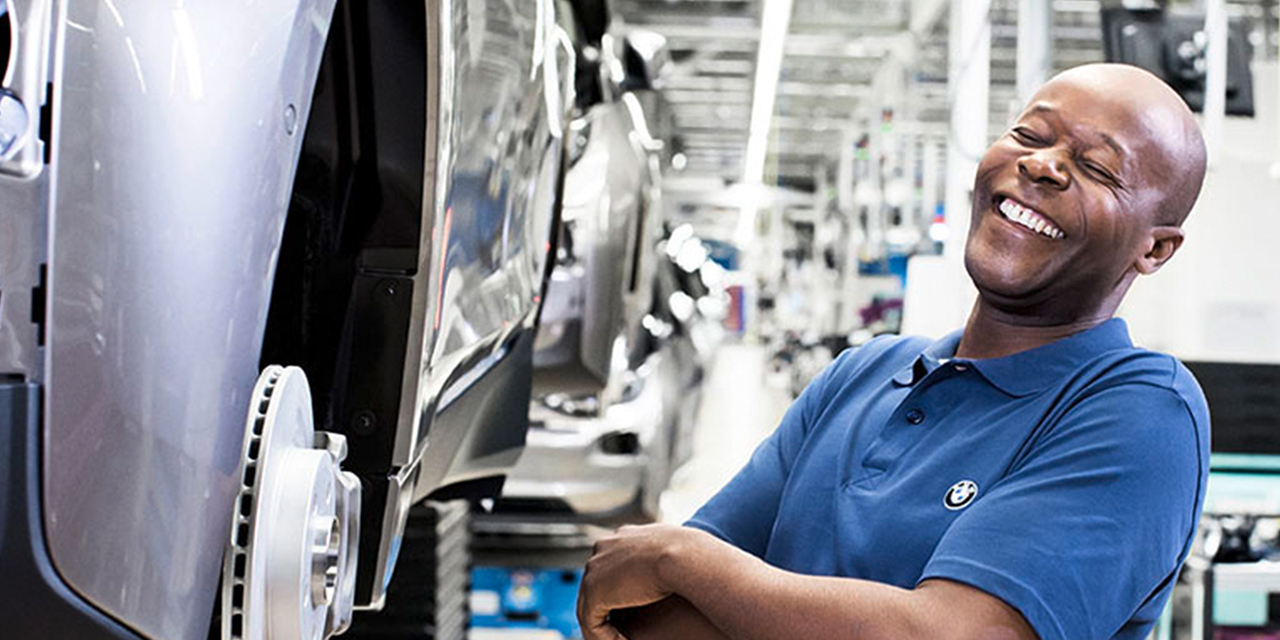 The picture shows a laughing worker in the BMW production.	