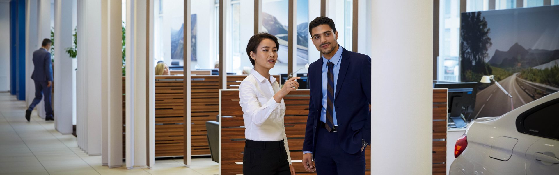 Two colleagues in a BMW dealership having a conversation
