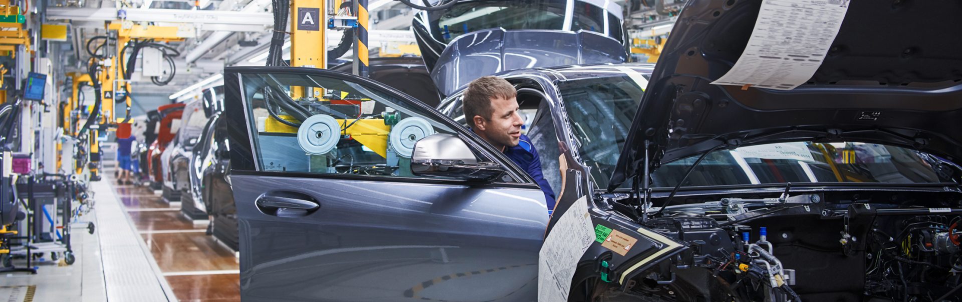 The picture shows a production worker on a BMW Group production line.