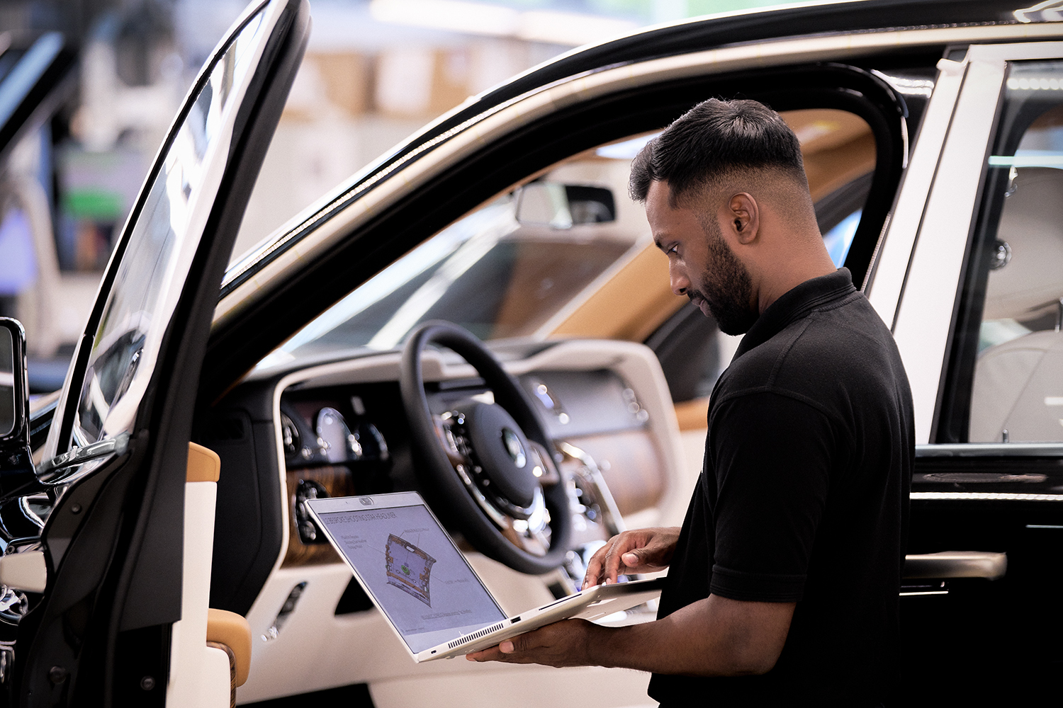 Rolls Royce Manufacturing employee analysing car data.