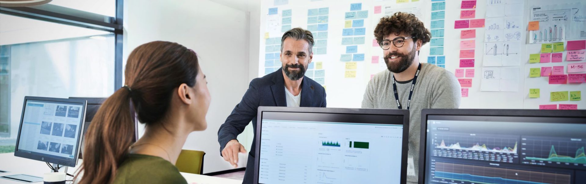 Three IT colleagues chat across the desk