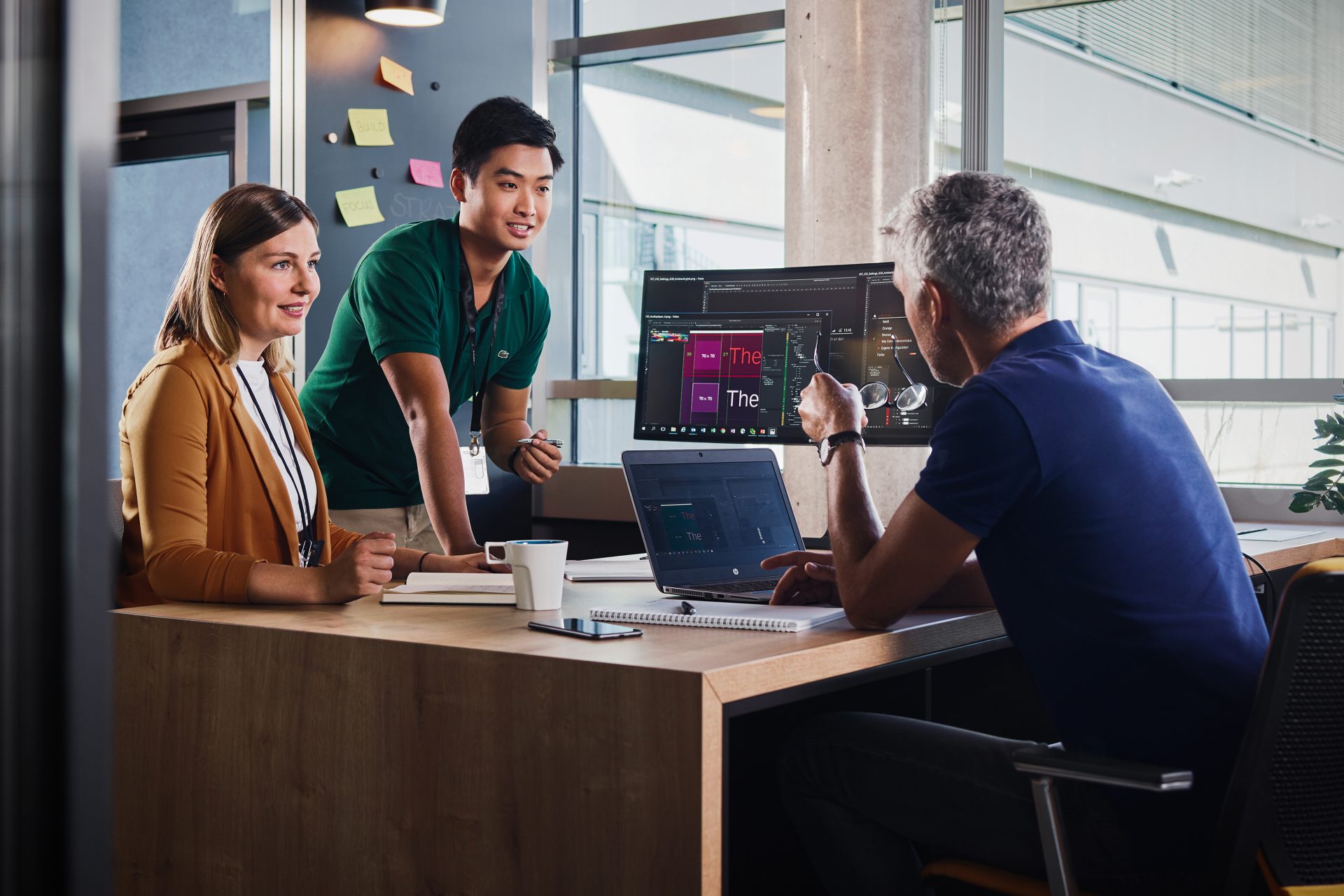  Three male students and a female student are looking at a computer.