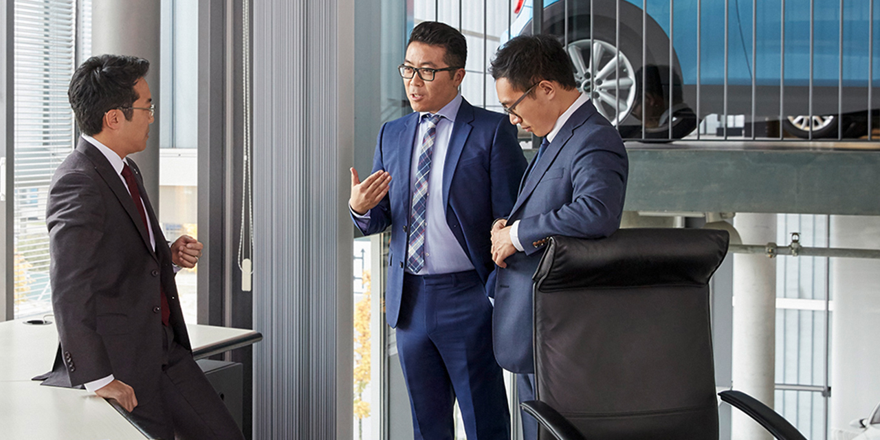 The picture shows a meeting of three male facility management professionals at BMW.	