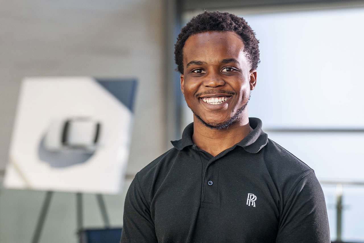 Tmak, an intern for Bespoke Leather Manufacturing smiling at the camera