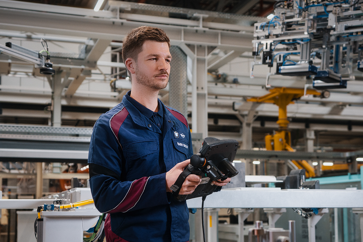 A process technician is working with a robot