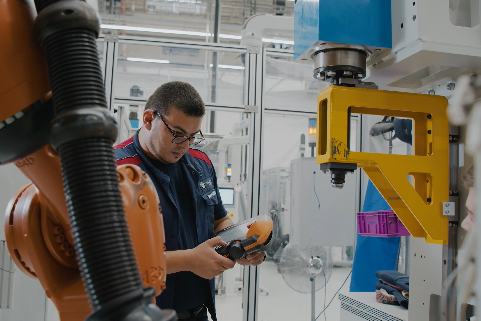 The picture shows Tarik maintaining a production machine.