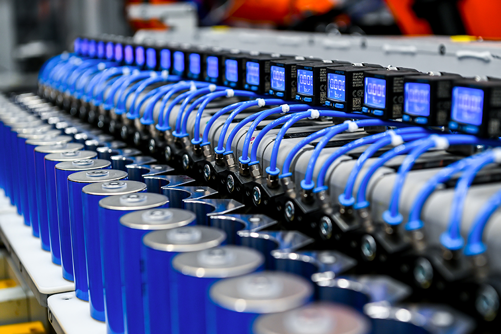 Two BMW Group employees working at a car energy module