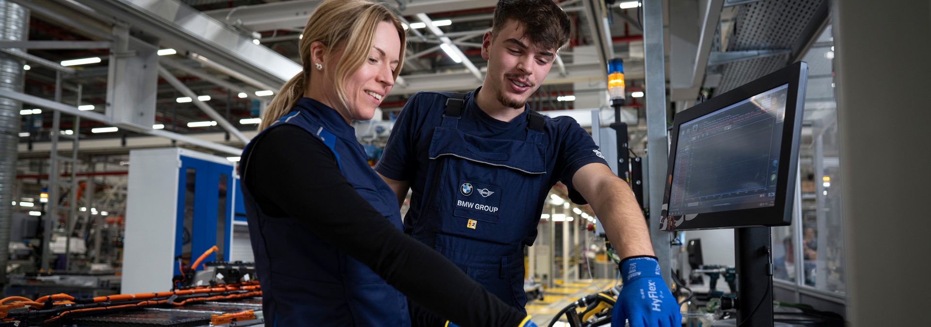 The picture represents the job culture by showing two BMW production employees.  