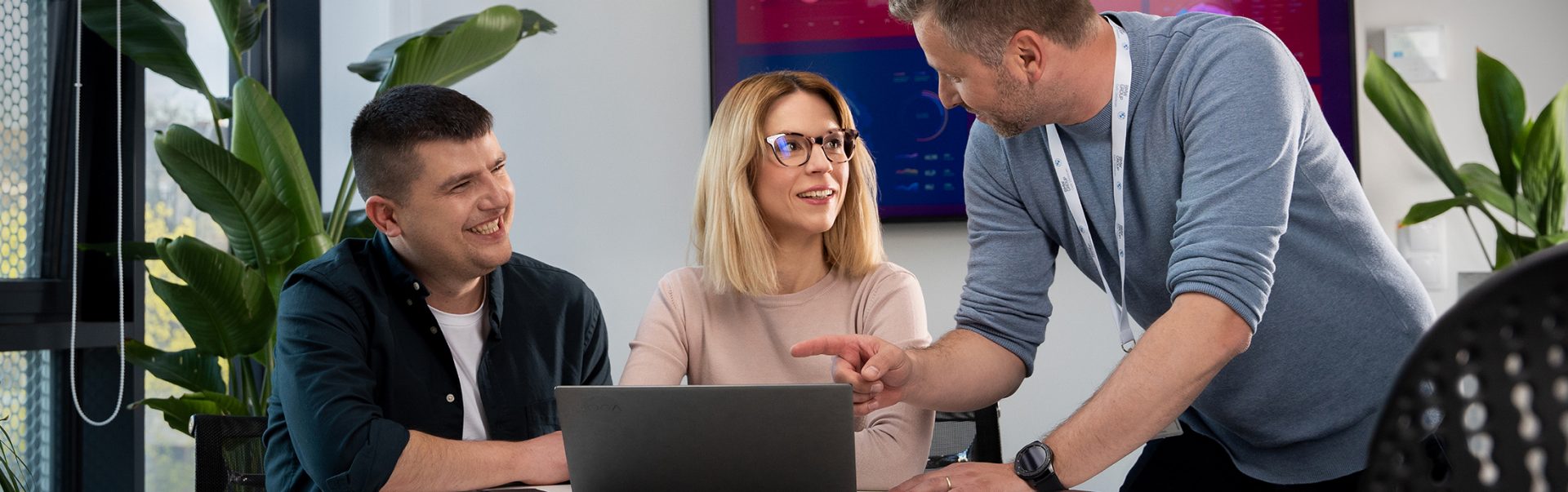 BMW Group employees are having a discussion in front of a computer.