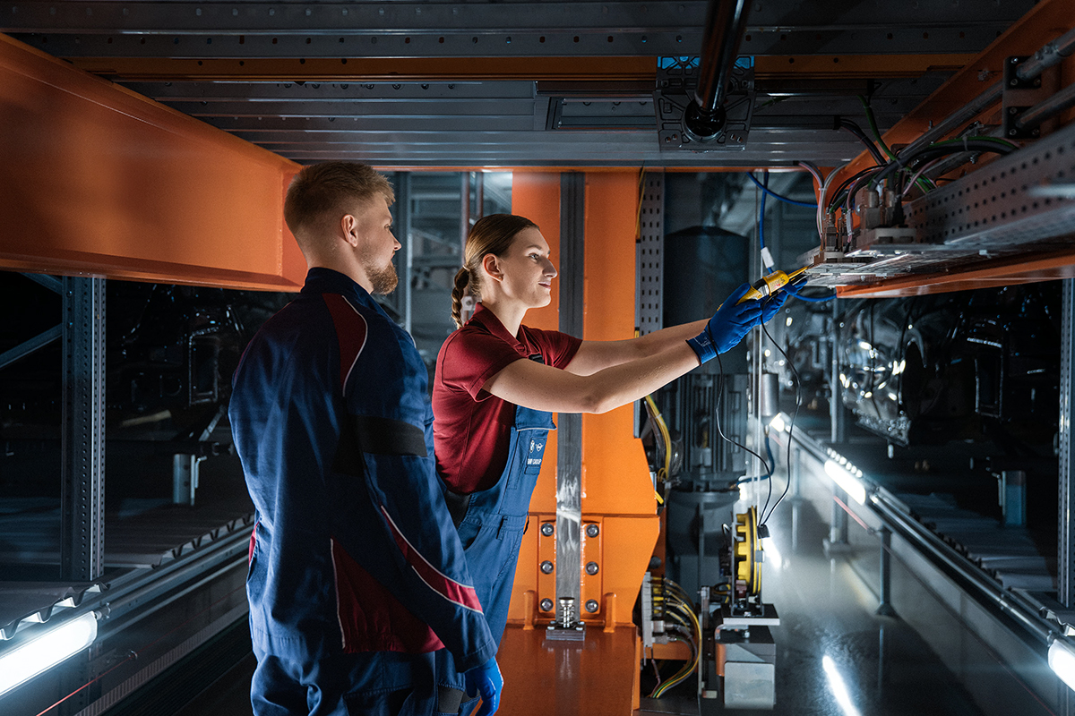 Two trainees are working in a server room in production.