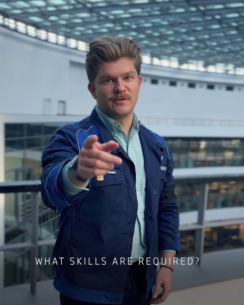 A male trainee pointing at the camera, answering the question "What skills are required?"