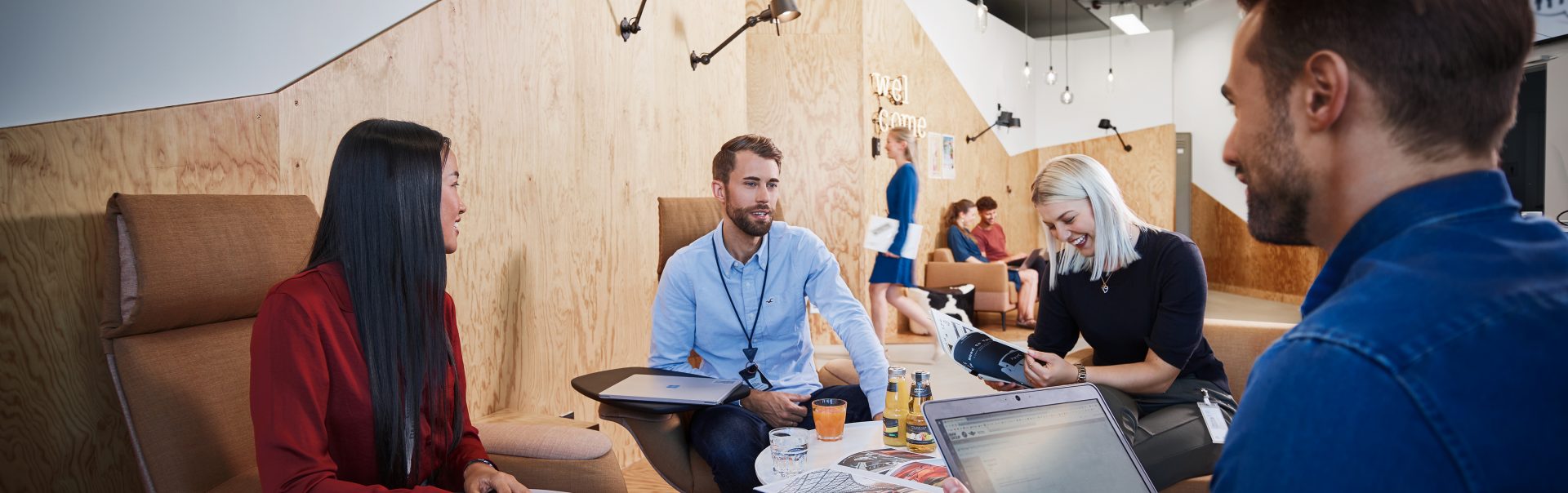 A group of students having a fun conversation in an innovative office environment.