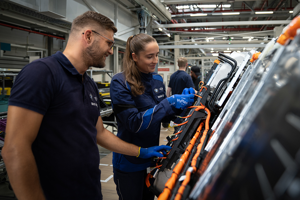 Egy BMW gyártósori munkásnő egy energiamodulon dolgozik