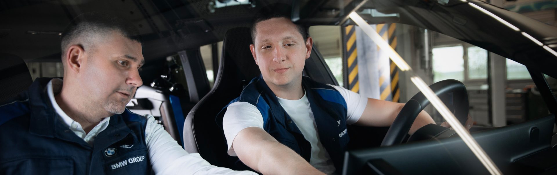 Két BMW Group mérnök dolgozik egy autóban.