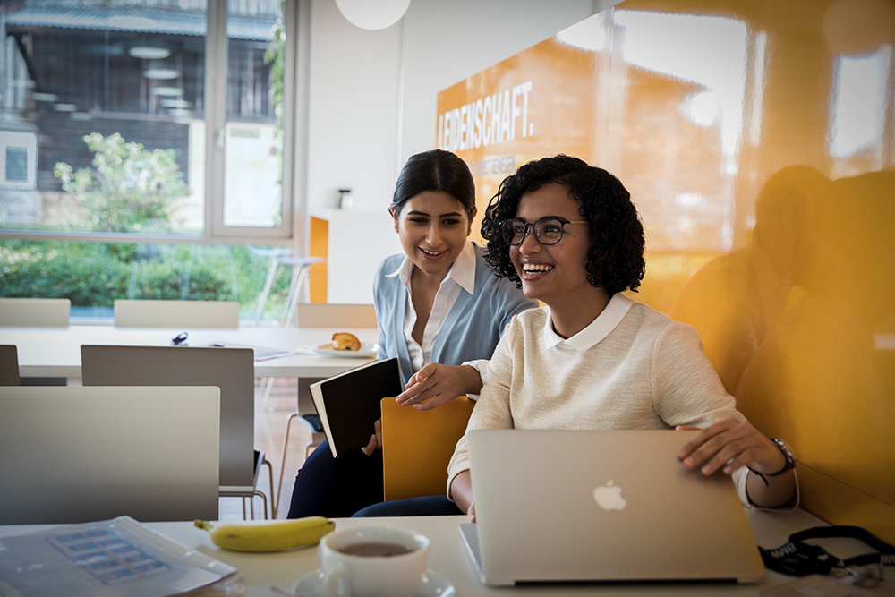 The picture shows two BMW Group employees holding a meeting.