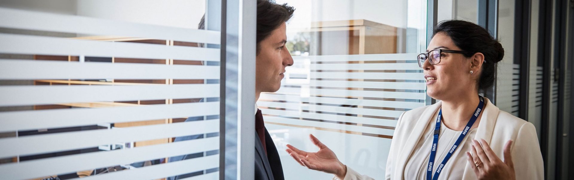 The picture shows a conversation between two BMW finance professionals, a male on the left and a female on the right.