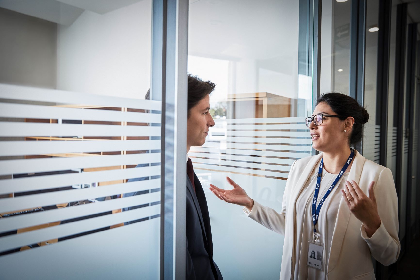 The picture shows a conversation between two BMW finance professionals, a male on the left and a female on the right.