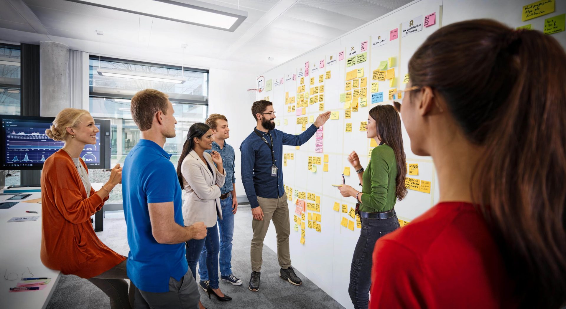 A group of BMW Group employees in a stand-up meeting.