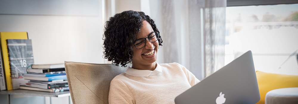 A colleague laughing and working on the laptop.