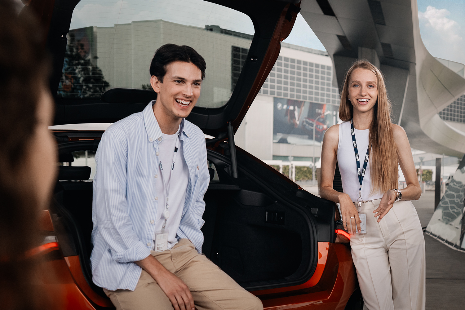 Three colleagues having a meeting, one of them sitting in the trunk of a BMW X2