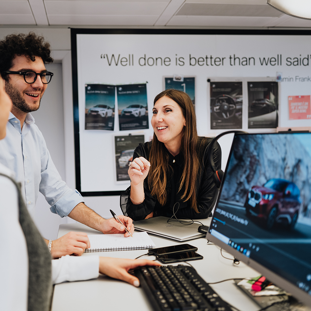 The image shows two colleagues having a conversation.