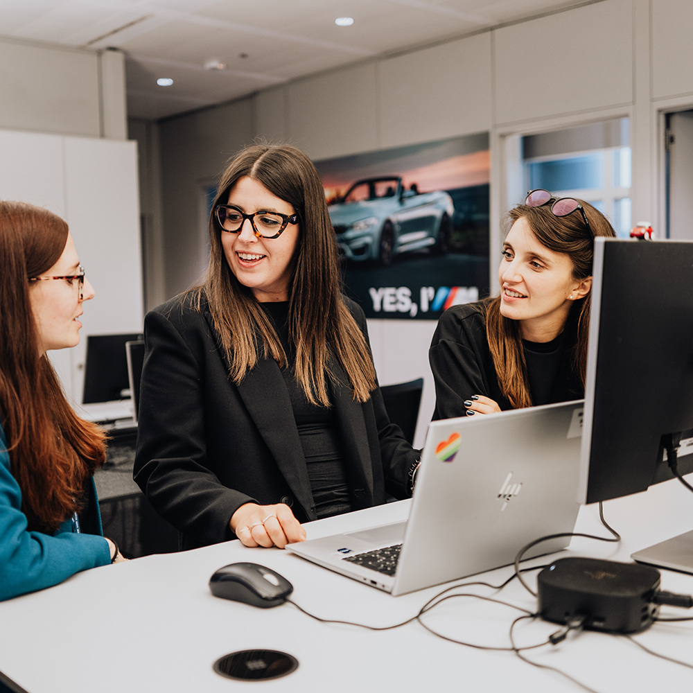 The image shows a group of employees in a meeting situation.