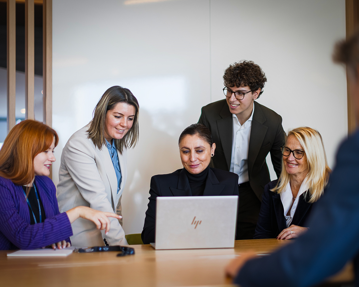 The image shows a group of employees in a meeting situation.