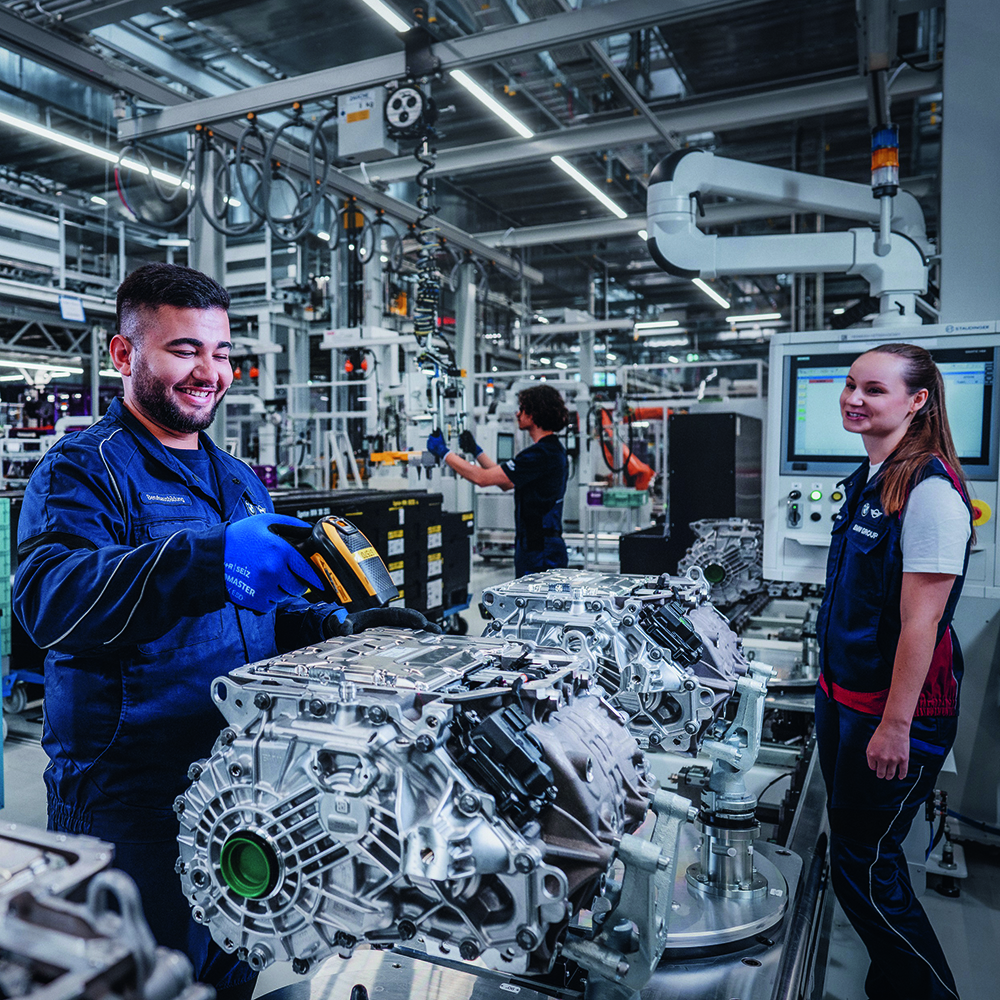 Two colleagues working in production with a motor.