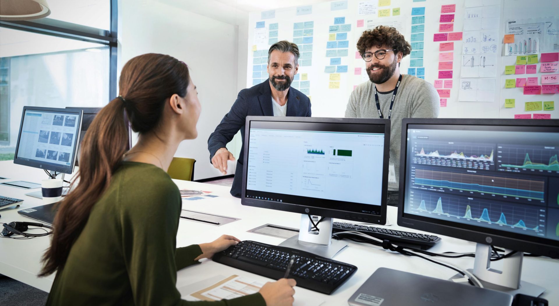 Three professionals of BMW, a female one and two male ones, are meeting in an office to discuss a new project.