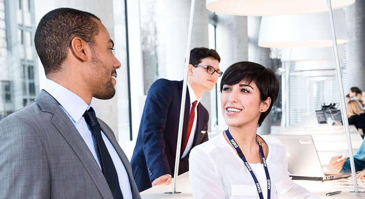 Three BMW employees are having a chat in the office. 