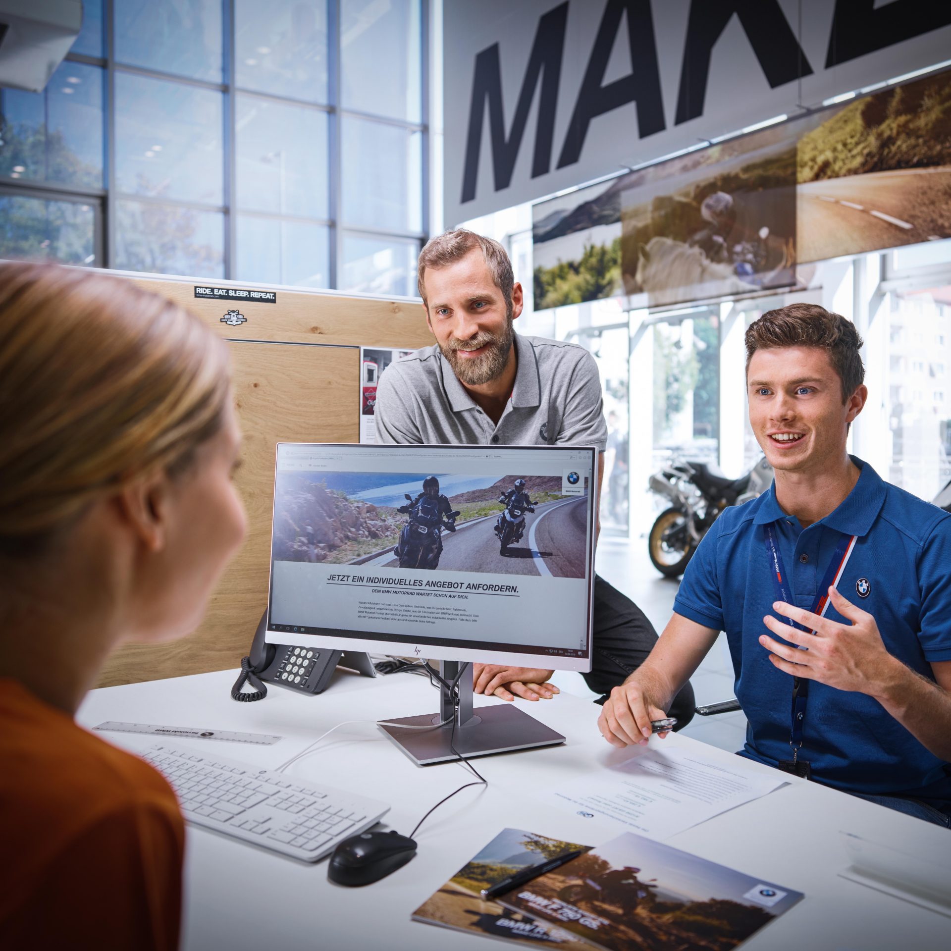 The image shows a group of BMW Group employees in a meeting.