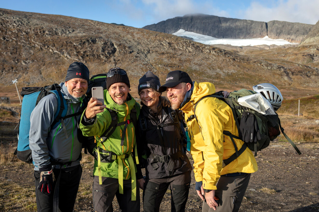 Four people taking a selfie while hiking in the mountains.