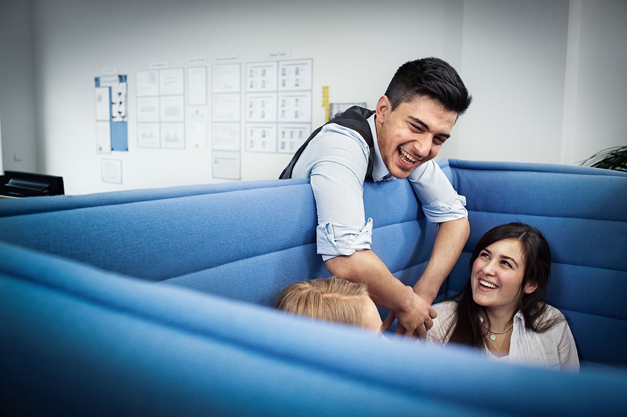 The picture shows a group of BMW employees in a lounge area.