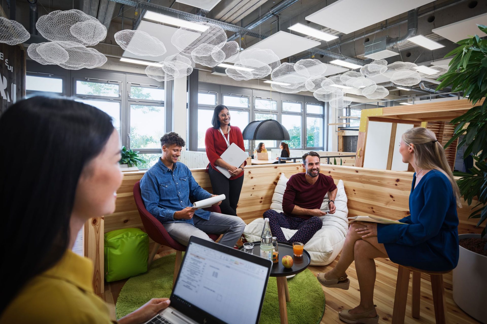 A group of students having a conversation in a modern office environment