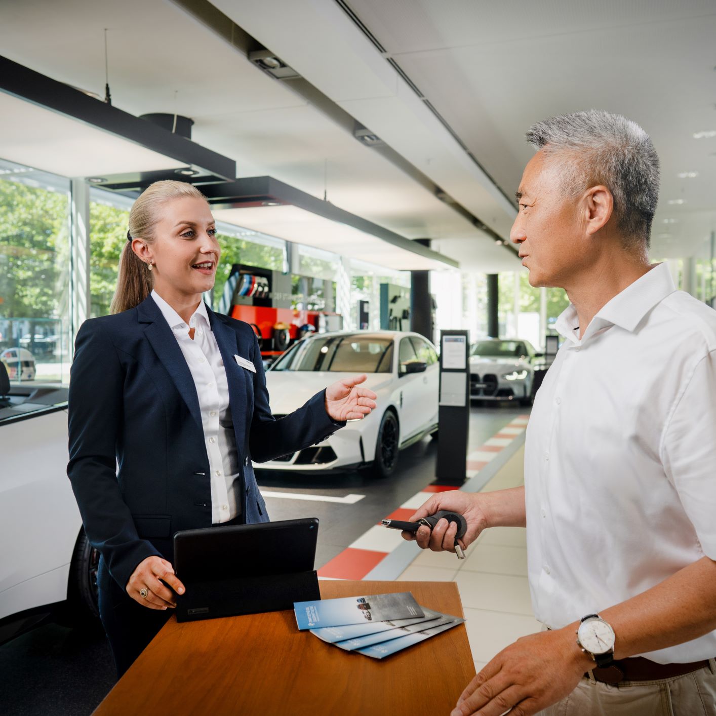 The image shows two BMW Group employees having a conversation.