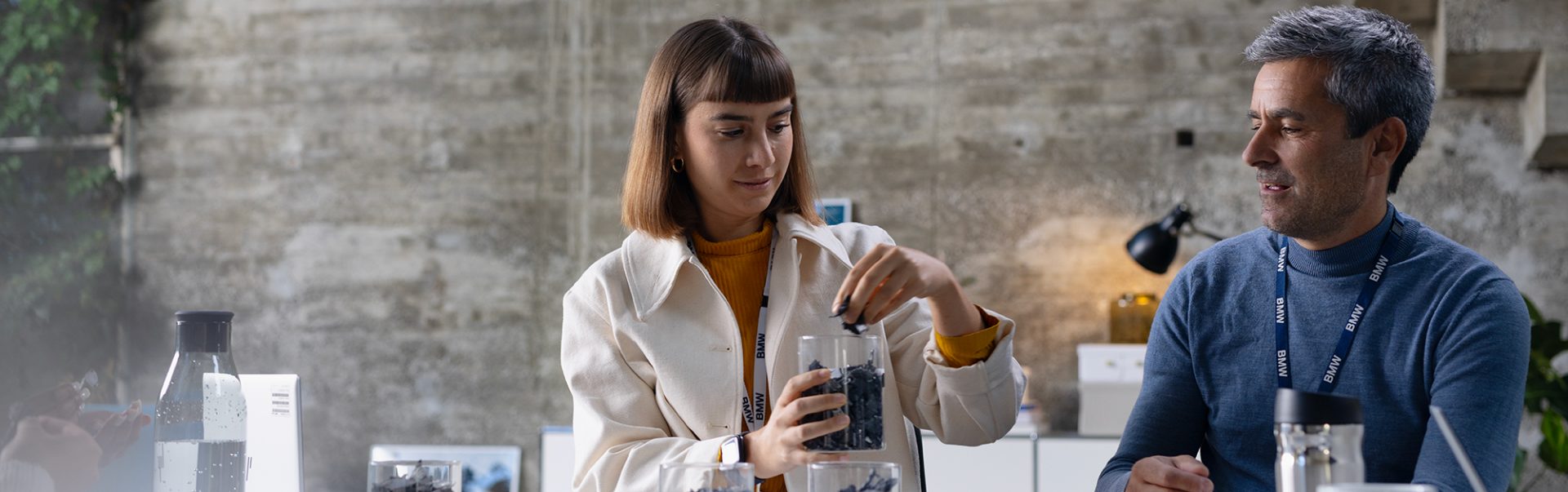 The picture shows two colleagues pinning notes on a wall.