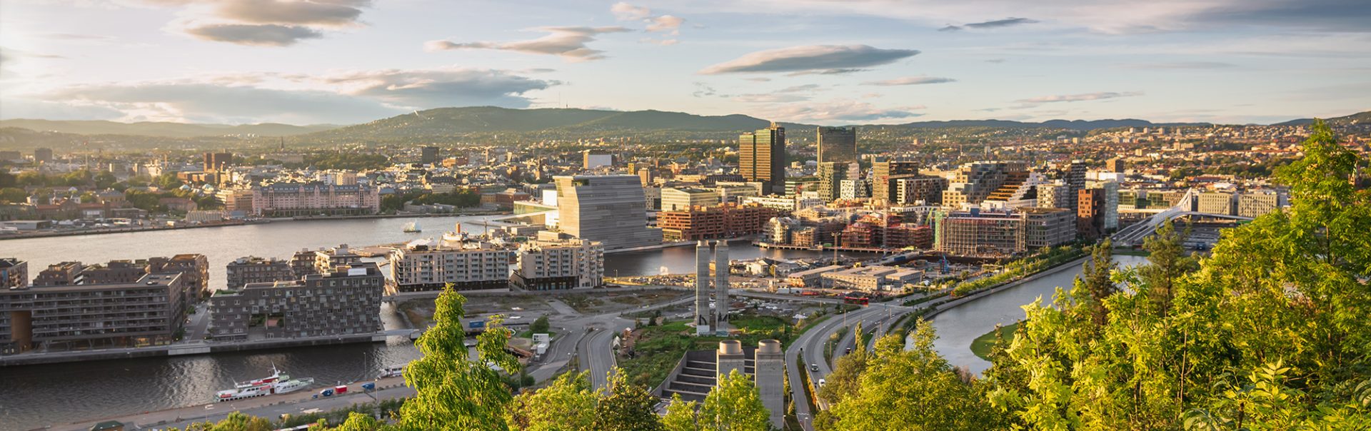 Sunset Panorama from above Ekebergparken over Sorenga District towards Oslo Cityscape with Oslo Harbor in late afternoon light close to sunset. Oslo City, Norway, Scandinavia, Northern Europe