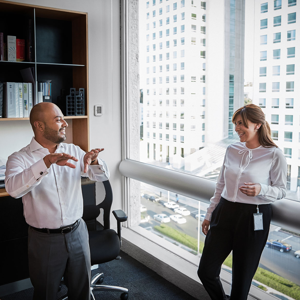 The image shows two colleagues having a conversation.