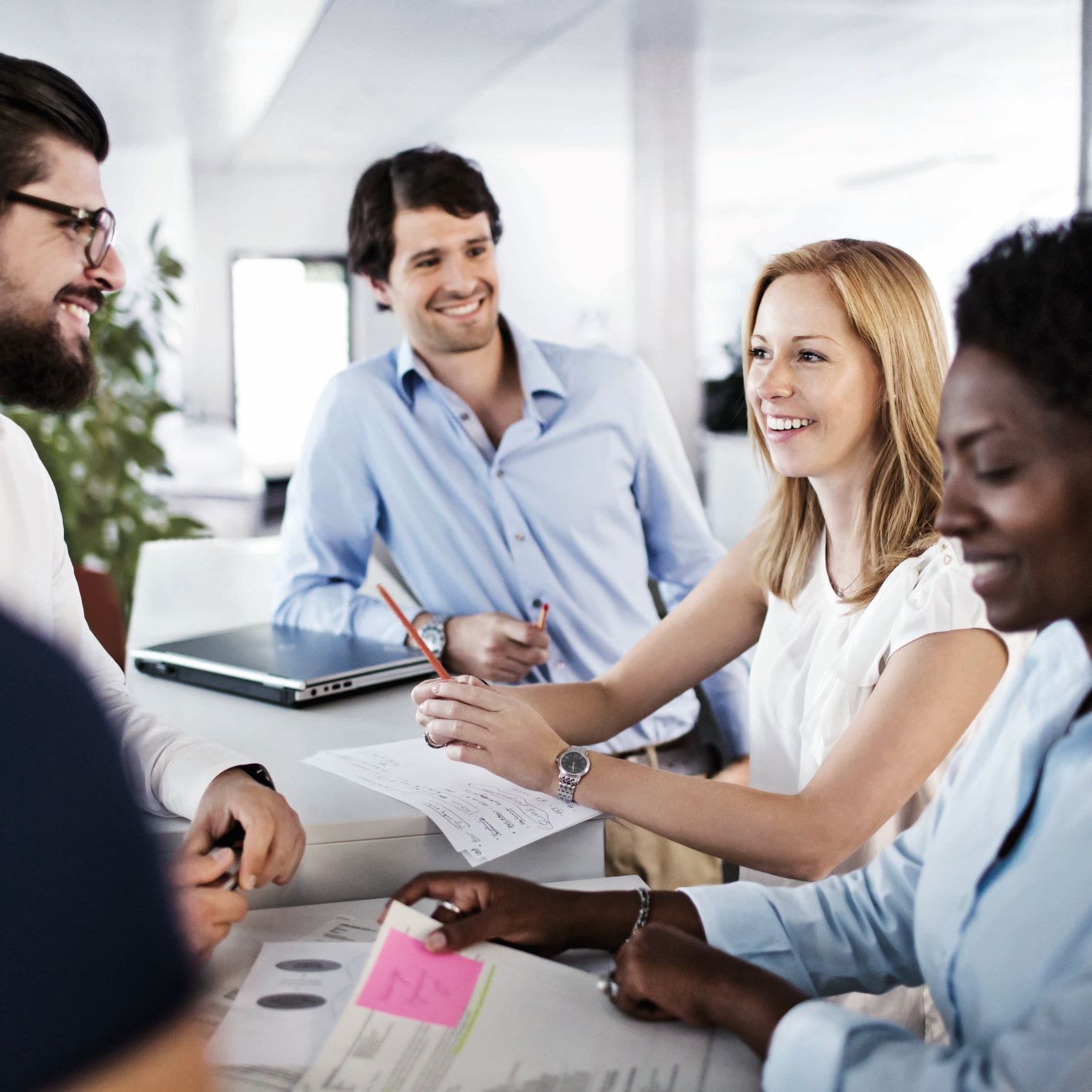 The image shows a group of employees in a meeting situation.