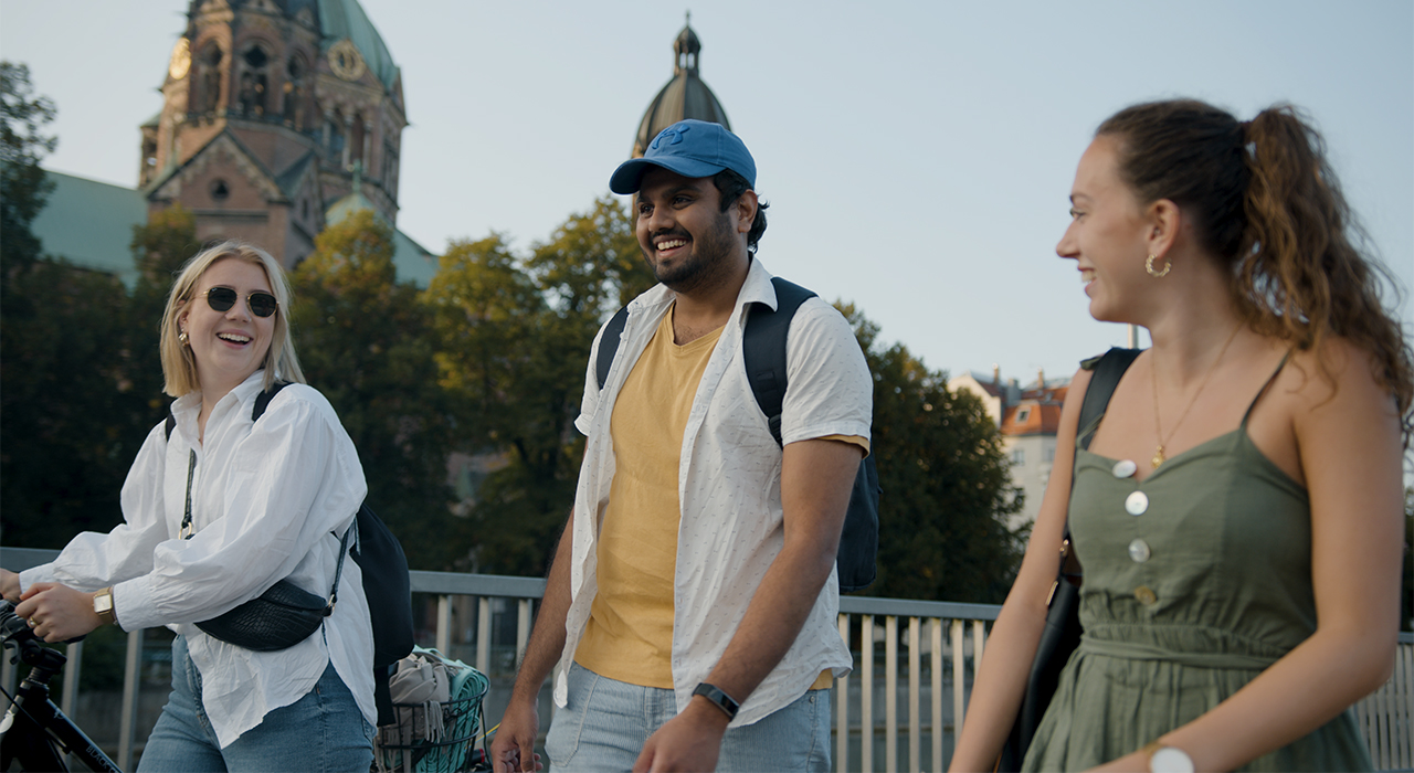 Three students talk to each other outside.