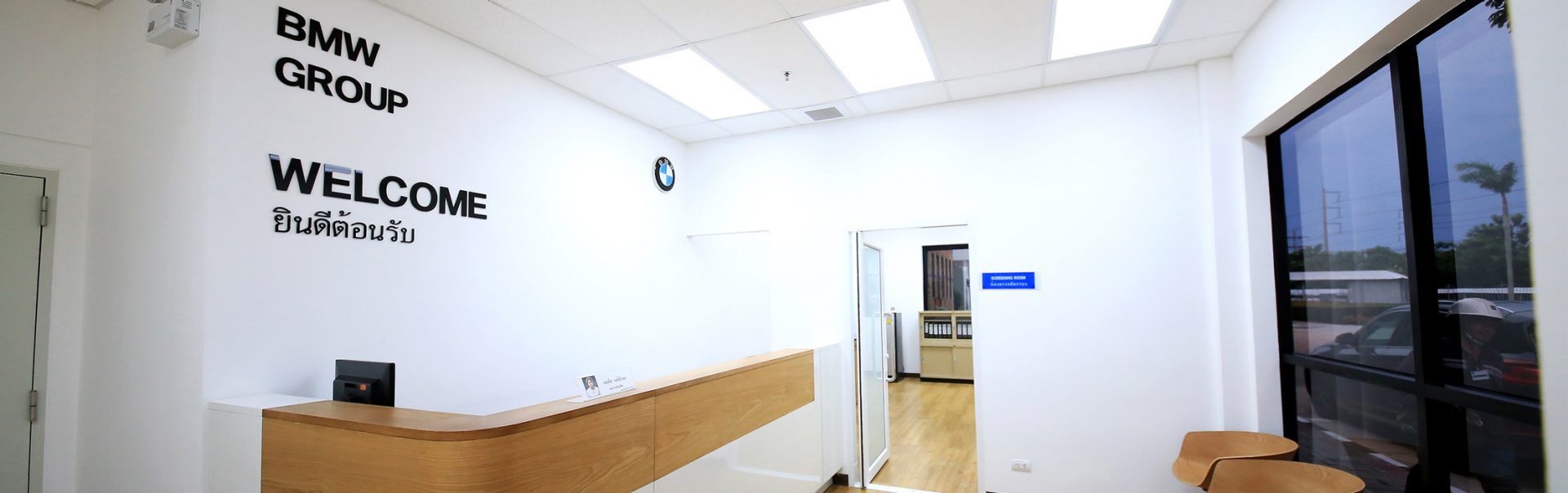 The picture shows a welcome desk at a BMW facility.