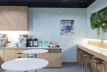 The picture shows an office kitchen with tables.