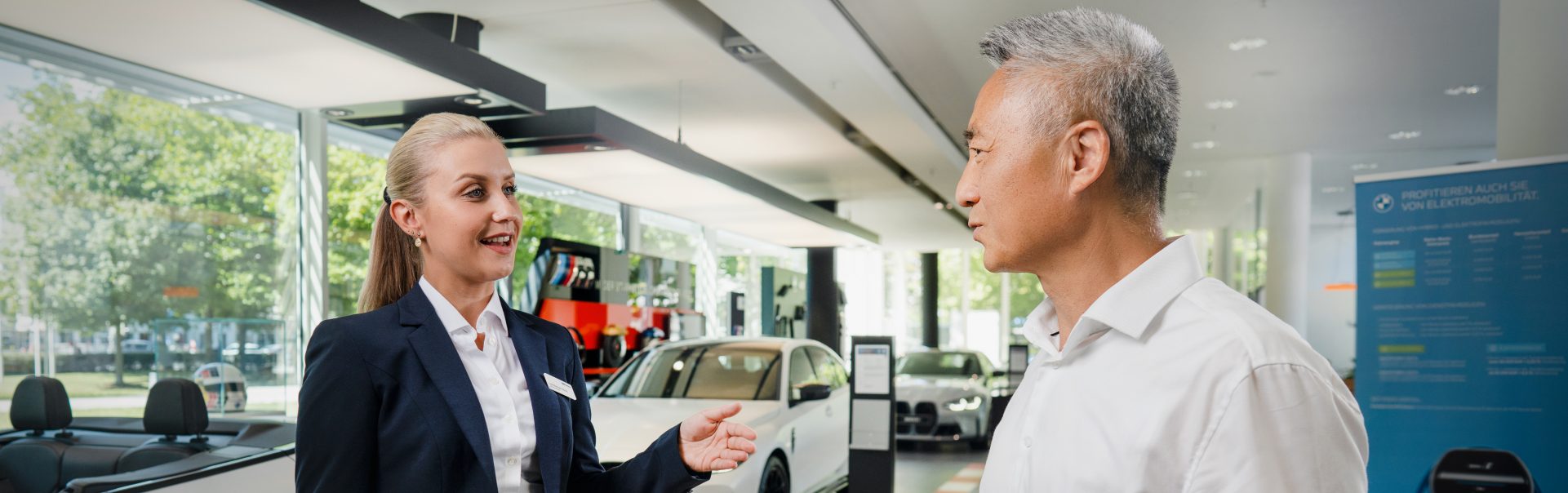 The image shows a meeting situation between a customer and BMW aftersales representative.