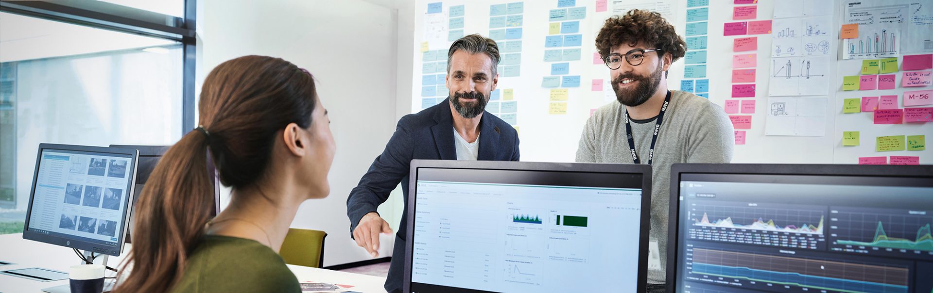 Three BMW professionals, a female one and two male ones, are meeting in an office to discuss a new project.