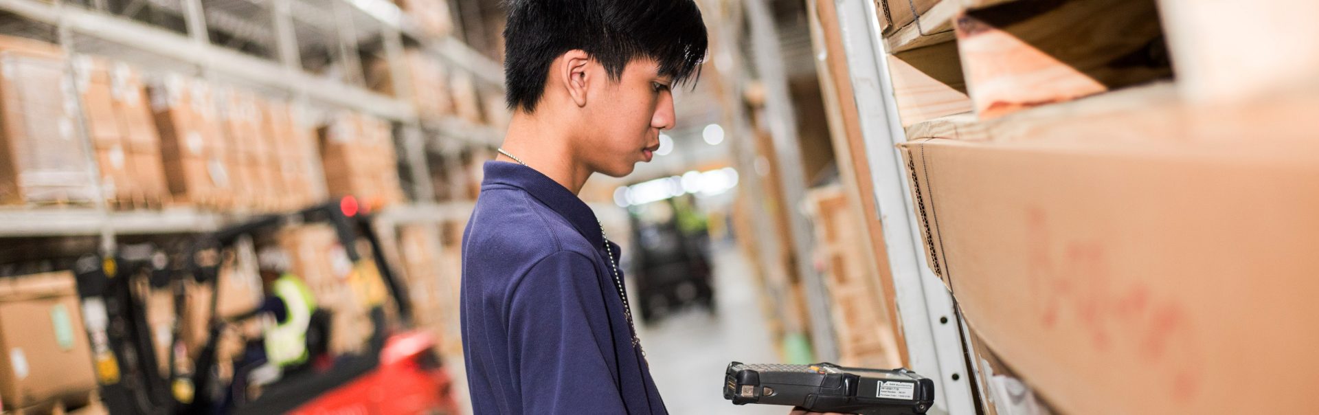 Apprentice working in logistics with hand scanner