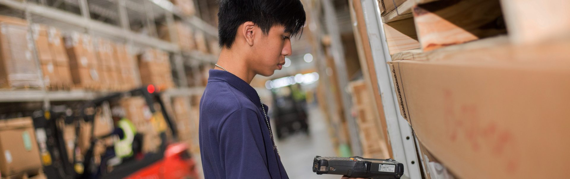 Apprentice working in logistics with hand scanner